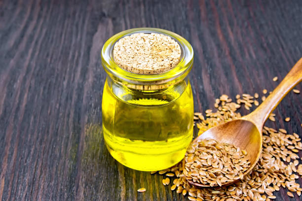 istock Oil linenseed with spoon on dark board 940879864