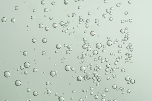 Small fizz bubbles flowing over a light green background.