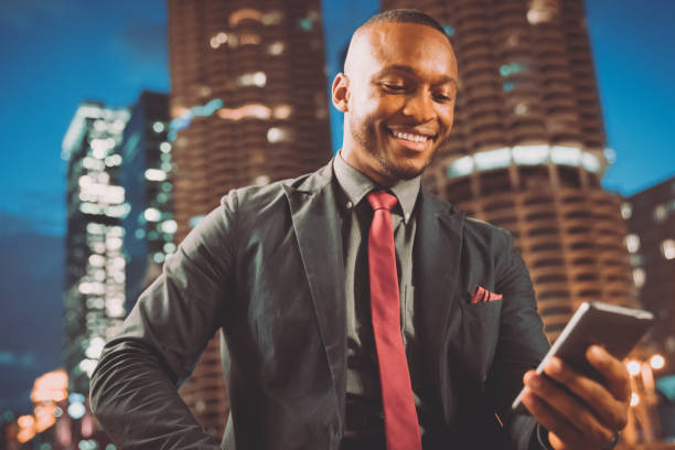 istock Smiling businessman checking messages on mobile phone in chicago 940884596