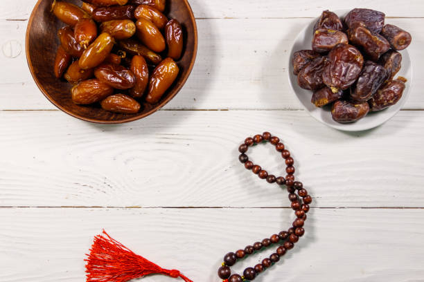istock Dates fruit and prayer beads on white wooden table. Top view 940886148