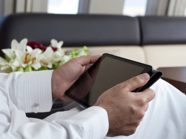 Saudi Arab Businessman Hands Holding and Using Tablet stock photo