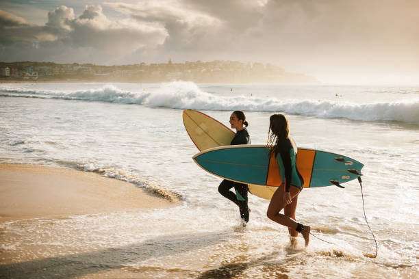 istock Modern determined girls go surfing 940889246