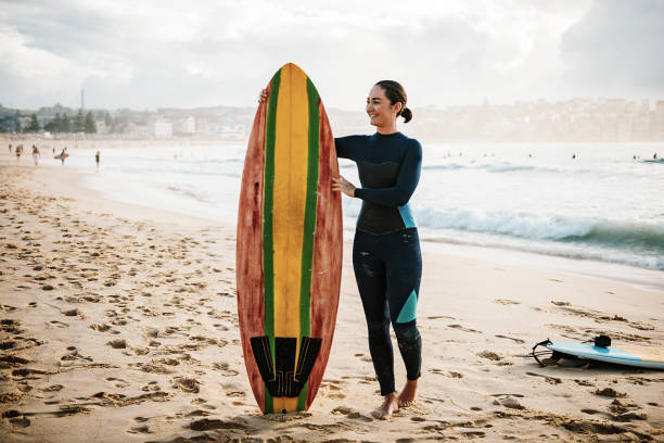 istock Portrait of female surfer with board 940889408