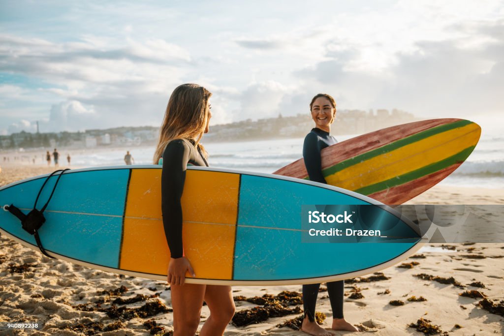 Two female friends with surfboards Surfing is a way of living in Australia and young and mature sporty women go surfing every morning. Surfing Stock Photo