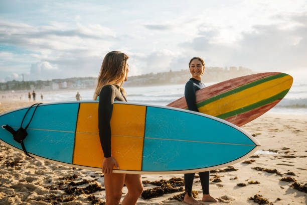two female friends with surfboards - surf imagens e fotografias de stock