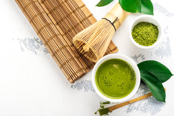 istock Green matcha tea drink and tea accessories on white background 940895756