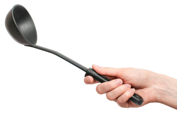 istock black plastic kitchen ladle in hand isolated on white background 940897584
