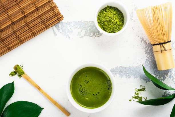 istock Green matcha tea drink and tea accessories on white background 940898150