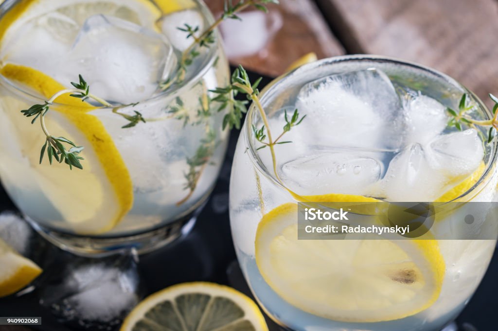 Citron, cocktail de thym et de la glace sur fond rustique foncé, gros plan. Rafraîchissante boisson cocktail jaune de l’alcoolique. - Photo de Gin libre de droits