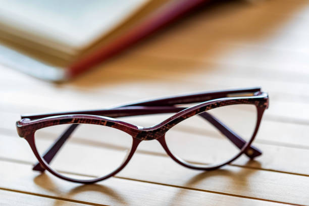 istock Glasses and open book on wooden table close 940902240