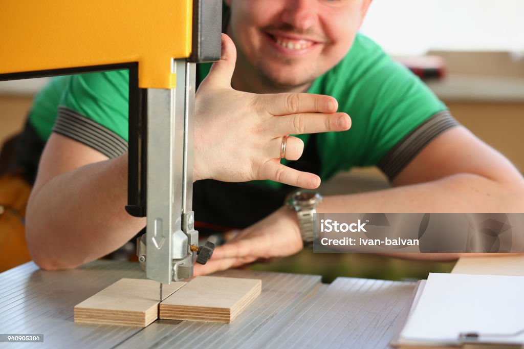 Happy smiling worker wearing yellow hard hat Happy smiling worker wearing yellow hard hat shows four fingers portrait. Manual job workplace DIY inspiration fix shop hard hat industrial education profession career Machinery Stock Photo