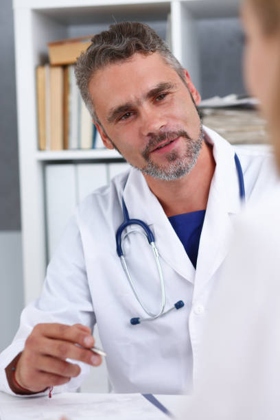 istock Smiling handsome mature doctor communicate 940905370