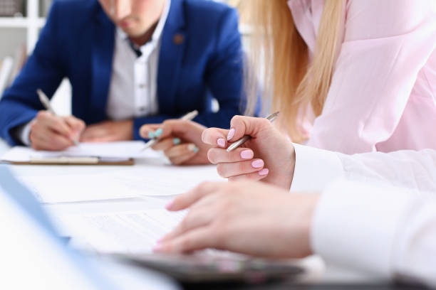 istock Group of people hold silver pen ready to make 940905696