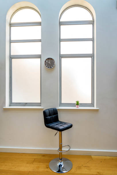istock Empty high chair next to cactus in flower pot in a bright window and clock on wall 940910918