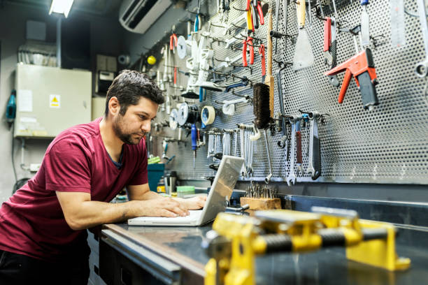 istock Man in a bicycle repair shop using a laptop computer Running a business 940911158