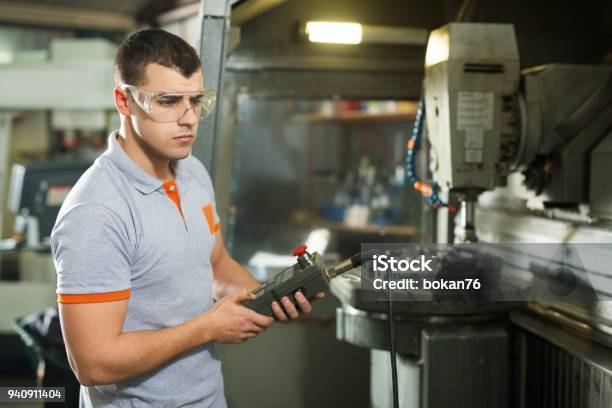 Metal Worker Working On Cnc Machine In Factory Stock Photo - Download Image Now - CNC Machine, Milling Machine, Accuracy