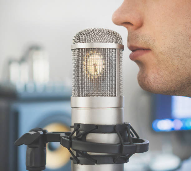 istock Man near microphone in the record studio. 940915322