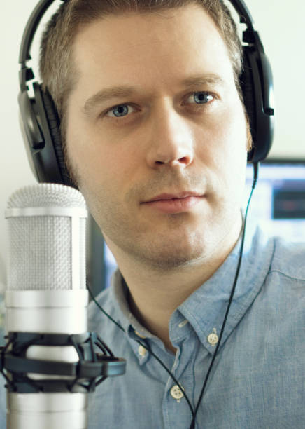 istock Handsome man near microphone on the radio station. 940915332