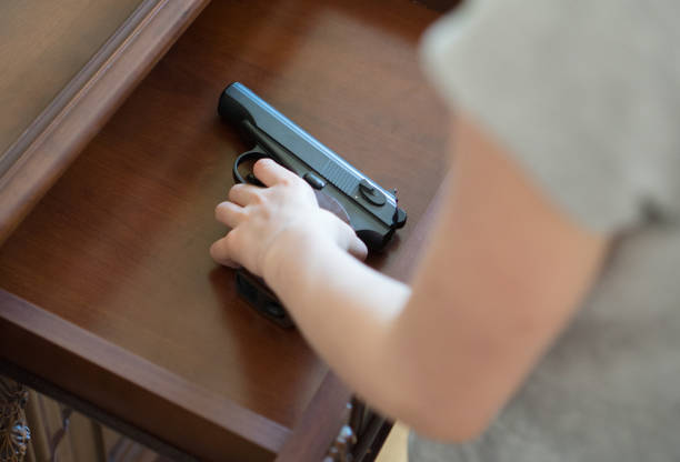Child found pistol in drawer at home. stock photo