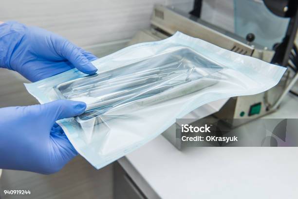 Close Up Dentist Assistants Hands Holding Packaged With Vacuum Packing Machine Medical Instruments Ready For Sterilizing In Autoclave Dental Office Selective Focus Space For Text Stock Photo - Download Image Now
