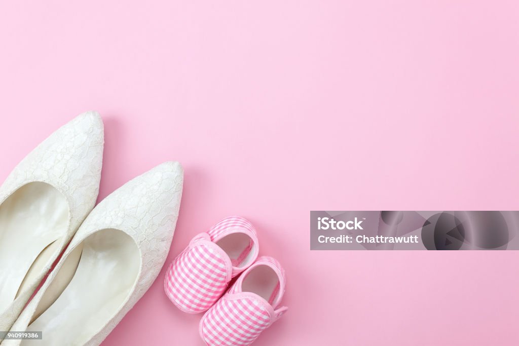 Top view aerial image of decoration Happy motherâs day holiday background concept.Flat lay sign of season the pink rose with clothing woman & kid and child toys  on pink paper at home office desk. Anniversary Stock Photo