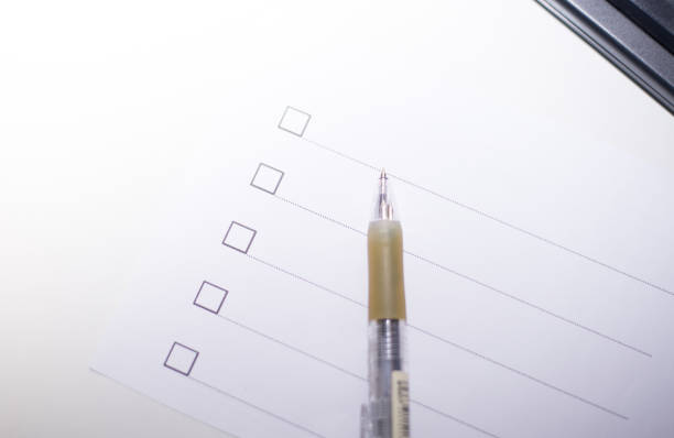 istock Close up pen with checklis box on white paper. 940922574