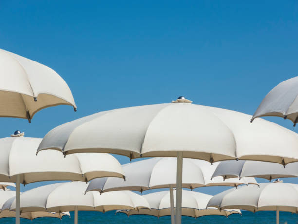istock Beach umbrellas, gazebos and sun beds at Italian sandy beaches. Adriatic coast. Emilia Romagna region 940922634