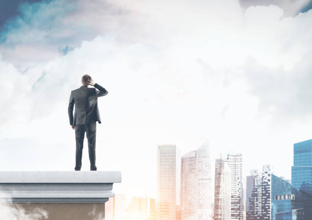 istock Rear view businessman scratching head, city view 940923070