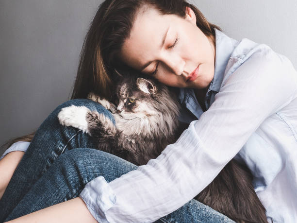 istock Stylish woman gently hugging kitten 940928850