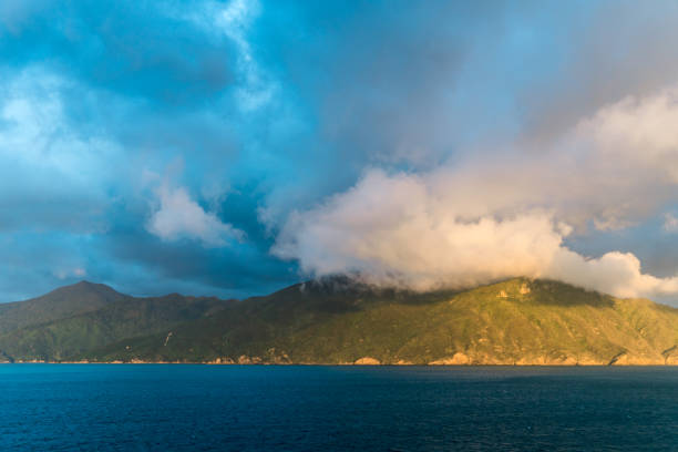sonnenlicht auf cloud und berg in der nähe von picton, neuseeland - marlborough region sunrise new zealand sea stock-fotos und bilder