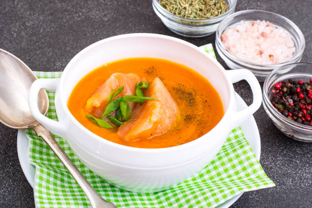 istock Carrot, pumpkin cream soup with salmon 940932298