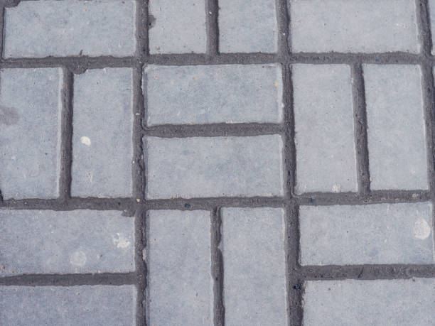 istock Interlocking paving with gray and white concrete blocks Concrete products Construction industry Paved ground 940933810