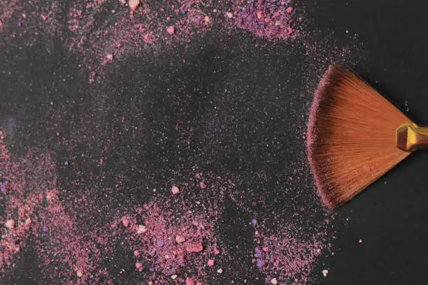 Photo of close up. background image of a brush smears grains of powder on a black background