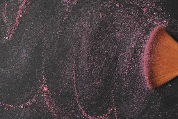 Photo of close up. background image of a brush smears grains of powder on a black background