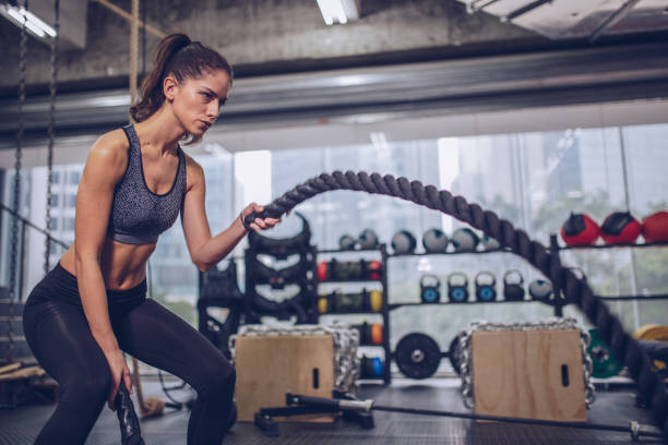 istock Young Woman Excerising With Ropes 940937832