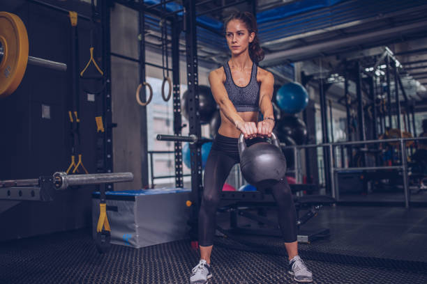 istock Young woman exercising in gym 940937968