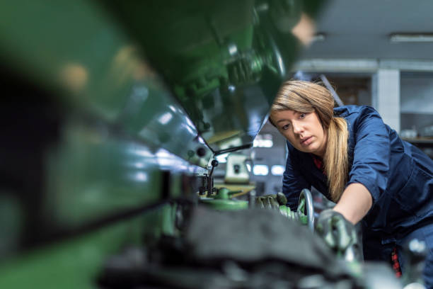 frau arbeitet an einem internen schleifmaschine. stadium der metallveredelung teile - metallarbeiter stock-fotos und bilder