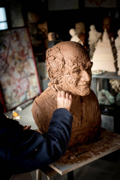 istock Sculptor's hand working on clay bust detail 940941566