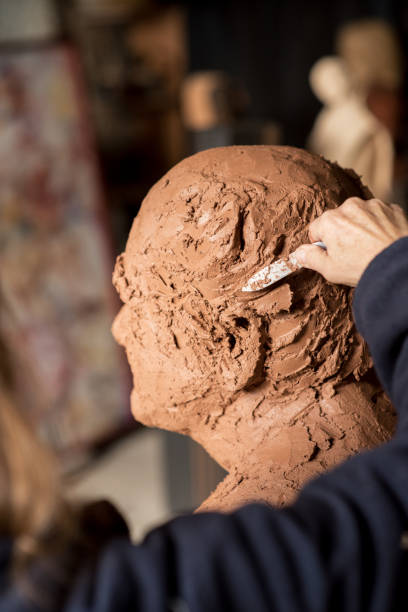 istock Sculptor's hand working on clay bust detail 940942048