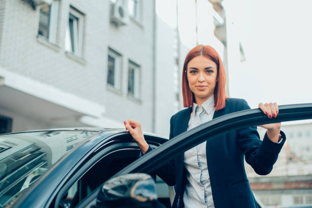 istock Business woman standing by a car 940945876