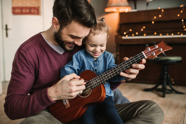 Daughter and father playing guitars stock photo