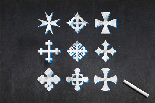 Blackboard with nine crosses of different shapes drawn in the middle.