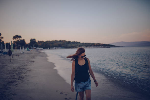 istock Beautiful woman walking at the beach 940948822