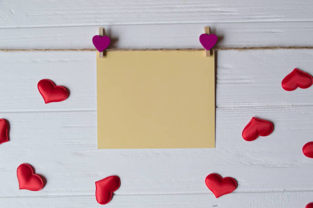 istock Yellow memo sheet fastened with a decorative pin on a white wooden board. 940949530