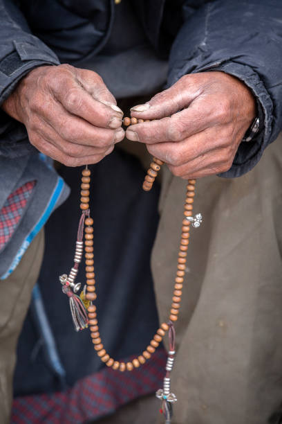 Old Tibetan man holding buddhist rosary in Hemis monastery, Ladakh, India. Hand and rosary, close up Old hands of a Tibetan man holding prayer buddhist beads at a Hemis monastery, Leh district, Ladakh, Jammu and Kashmir, north India. Close up ladakh region photos stock pictures, royalty-free photos & images