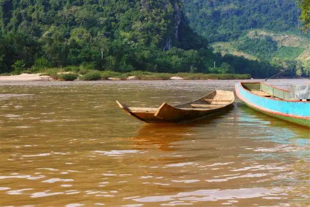 Long Tail wooden boat beside the river at Luangprabang, Laos