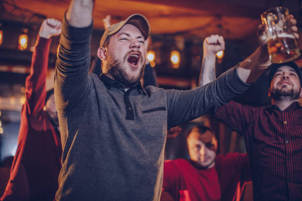 istock Young men watching game in sports bar 940957432
