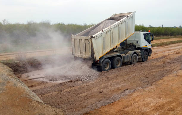 View of dump truck dumping gravel View of dump truck dumping gravel earthwork stock pictures, royalty-free photos & images