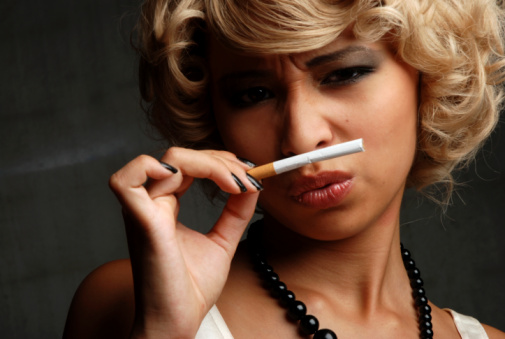 Woman smelling a cigarrette.