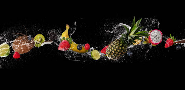 istock Pieces of fruit in water splash, isolated on black background 940967274